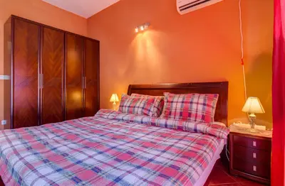 a bedroom with a bed with a checkered blanket at Apartments Varja in Sveti Stefan