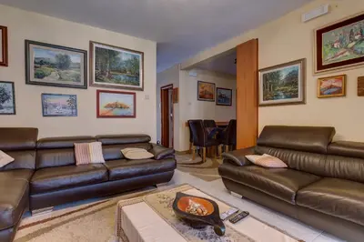 a living room with leather couches and a table at Apartments Varja in Sveti Stefan