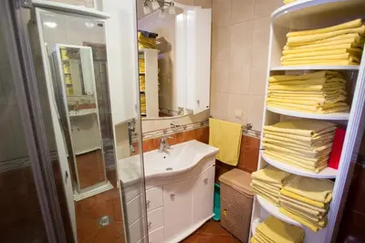 a bathroom with a sink and a shower and towels at Apartments Varja in Sveti Stefan