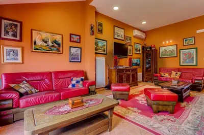 a living room with red couches and a tv at Apartments Varja in Sveti Stefan