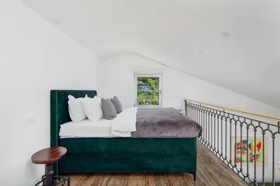 a bedroom with a bed with a green headboard at Carpe Diem Apartments in Kotor
