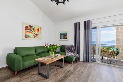 a living room with a green couch and a table at Carpe Diem Apartments in Kotor