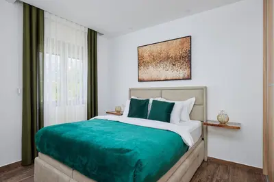 a bedroom with a large bed with green sheets at Carpe Diem Apartments in Kotor
