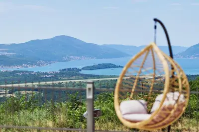 a hanging chair with a view of a body of water at Carpe Diem Apartments in Kotor
