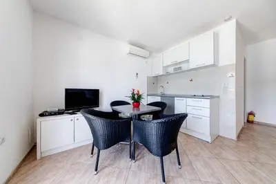 a kitchen with a table and chairs in a room at Apartments Tamaris in Tivat