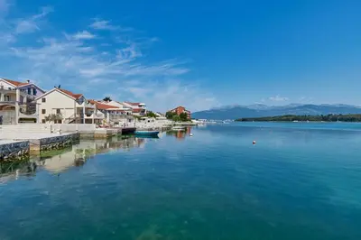 a large body of water with houses and boats at Apartments Tamaris in Tivat
