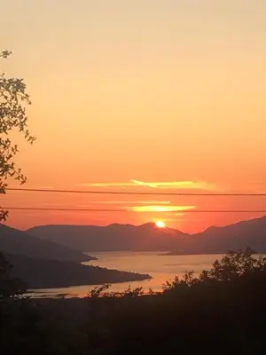 a sunset over a body of water with the sun at Apartment Jelena Sutvara in Kotor