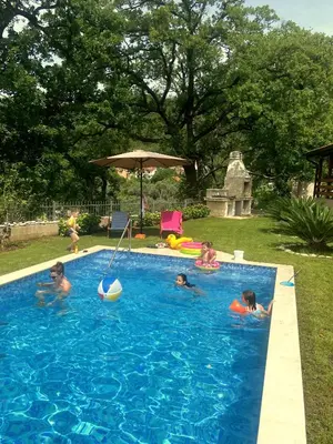 a group of children playing in a swimming pool at El Mar House in Petrovac na Moru