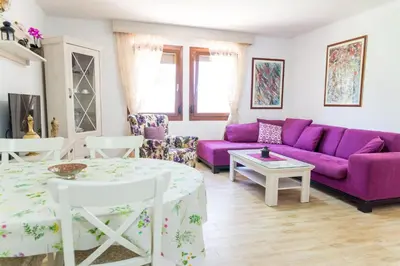 a living room with purple furniture and a purple couch at El Mar House in Petrovac na Moru