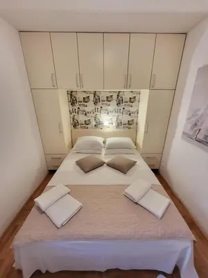 a large white bed in a room with white cabinets at Apartment Rachel in Petrovac na Moru