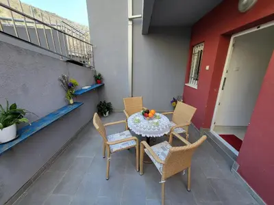 a patio with a table and chairs on a balcony at Apartment Rachel in Petrovac na Moru