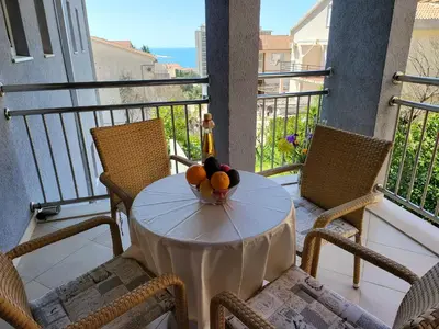 a table with a bowl of fruit on a balcony at Apartment Rachel in Petrovac na Moru