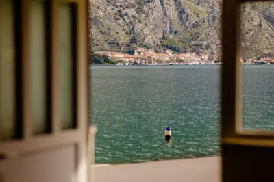a window view of a body of water with a bird at Sea Holiday Muo with Sea and City View in Kotor