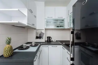 a kitchen with white cabinets and a pineapple on the counter at Old Town Summer Apartment in Kotor