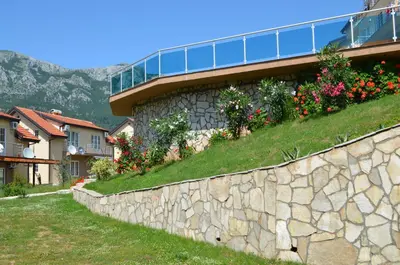 a stone retaining wall with flowers on the side of a house at Zubci mountain apartment in Bar