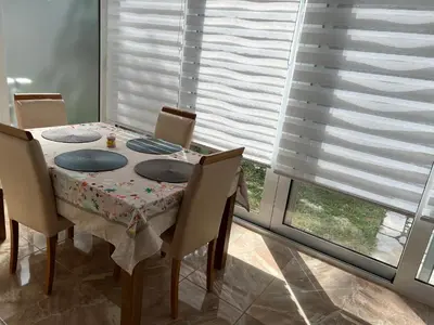 a dining room with a table and chairs and a window at Zubci mountain apartment in Bar