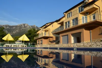 a hotel with a reflection in a pool of water at Zubci mountain apartment in Bar