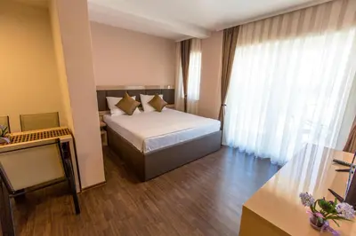a hotel room with a bed and a large window at Atlantic Hotel in Dobra Voda