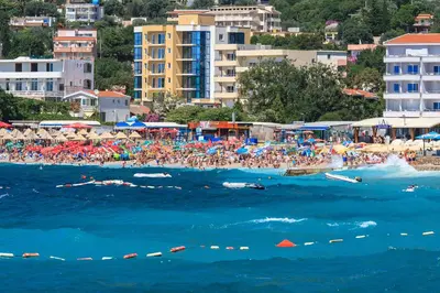 a crowd of people on a beach with the ocean at Atlantic Hotel in Dobra Voda