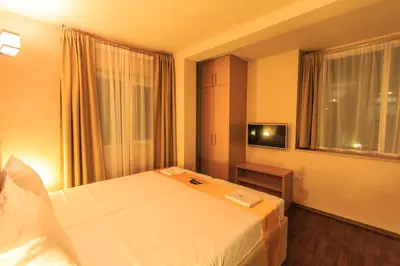 a hotel room with a bed and a television at Atlantic Hotel in Dobra Voda