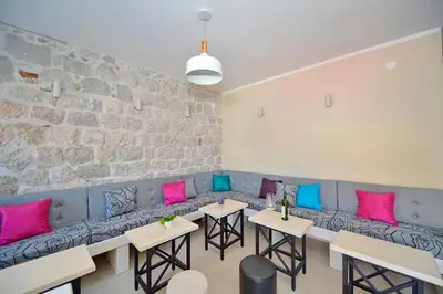a room with a couch with pink and blue pillows at Hostel Pupa in Kotor