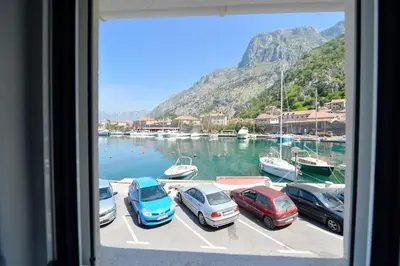 a group of cars parked in a marina with boats at Hostel Pupa in Kotor