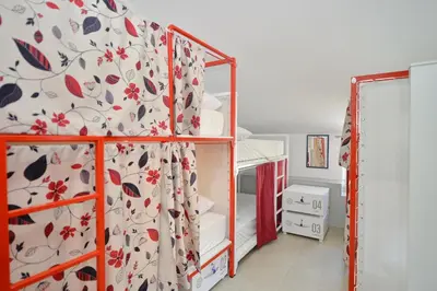 a bedroom with a bunk bed with a curtain at Hostel Pupa in Kotor