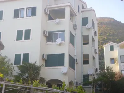 a white building with satellite dishes on it at Apartman Ozi in Petrovac na Moru