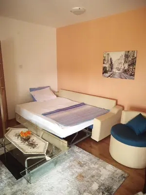 a small bedroom with a bed and a chair at Apartman Ozi in Petrovac na Moru