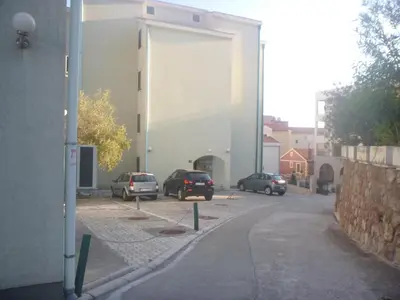 a group of cars parked on a street next to a building at Apartman Ozi in Petrovac na Moru
