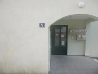 a building with a door with the number six at Apartman Ozi in Petrovac na Moru