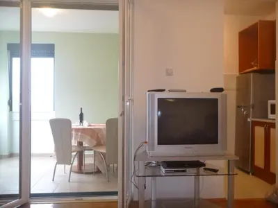 a living room with a television on a glass table at Apartman Ozi in Petrovac na Moru