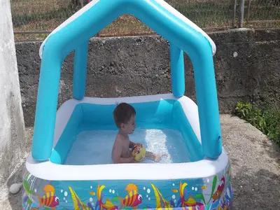 a young boy playing in a pool in a inflatable at Holiday Home Aksentijevic in Sutomore