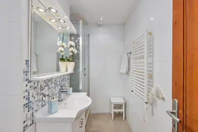 a white bathroom with a sink and a mirror at La Dolce Vita Apartment in Kotor
