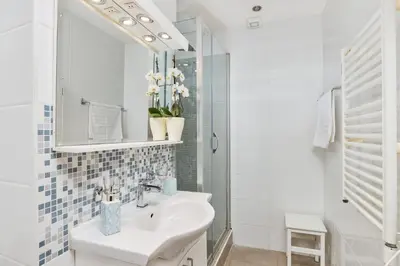 a white bathroom with a sink and a mirror at La Dolce Vita Apartment in Kotor