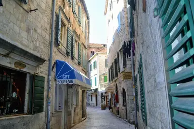an alley in an old city with a blue awning at La Dolce Vita Apartment in Kotor