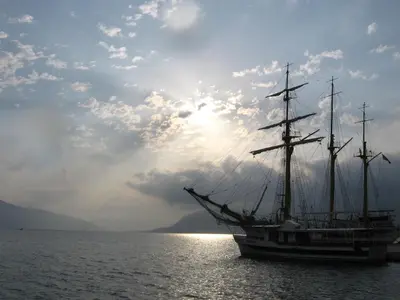 a boat in the water with the sun in the background at Star Home in Kotor