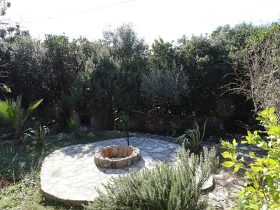 a patio with a fire pit in a garden at Star Home in Kotor