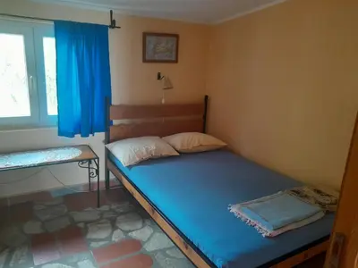 a bedroom with a bed with blue sheets and a window at Star Home in Kotor