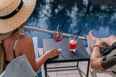 two people sitting at a table with two drinks at Hotel Eleven in Petrovac na Moru