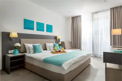 a bedroom with a bed with a tray of food on it at Hotel Eleven in Petrovac na Moru