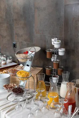 a table topped with wine glasses and bowls of food at Hotel Eleven in Petrovac na Moru