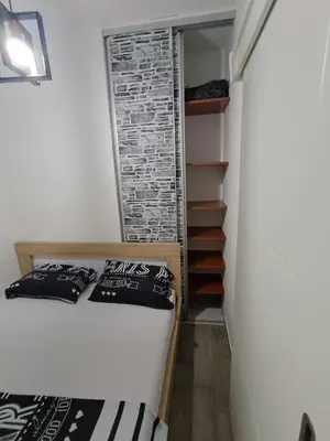 a small bedroom with a bed and a brick wall at Apartment Maska in Budva