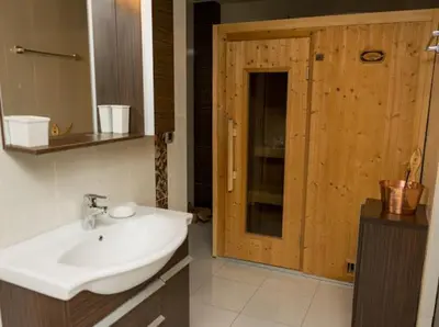 a bathroom with a white sink and a wooden door at Lux Villa Ivan Budva in Budva