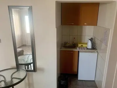 a small kitchen with a sink and a mirror at Apartments in villa Viktoria in Sutomore