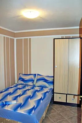 a bedroom with a bed with blue sheets and a cabinet at Apartments in villa Viktoria in Sutomore