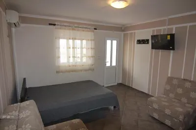 a room with a bed and a couch and a window at Apartments in villa Viktoria in Sutomore
