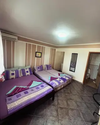 two beds in a room with purple at Apartments in villa Viktoria in Sutomore