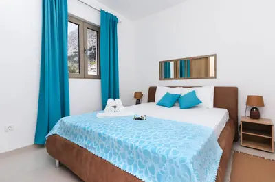 a bedroom with a large bed with blue curtains at Apartments Castello in Kotor