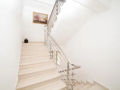 a staircase in a white house with a metal railing at Apartments Castello in Kotor